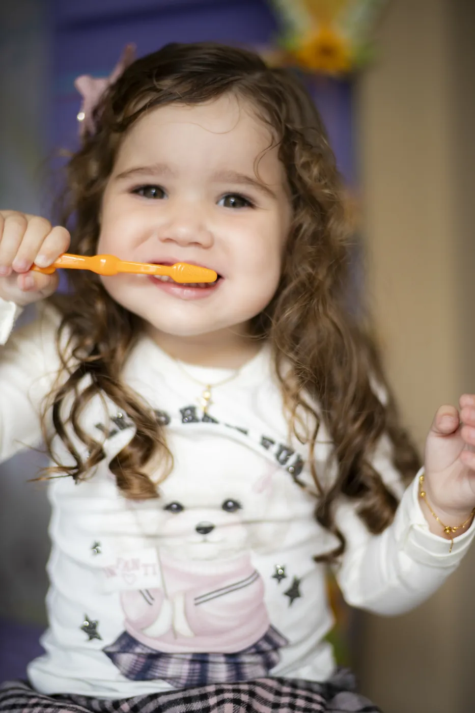 Menina escovando os dentes e sorrindo
