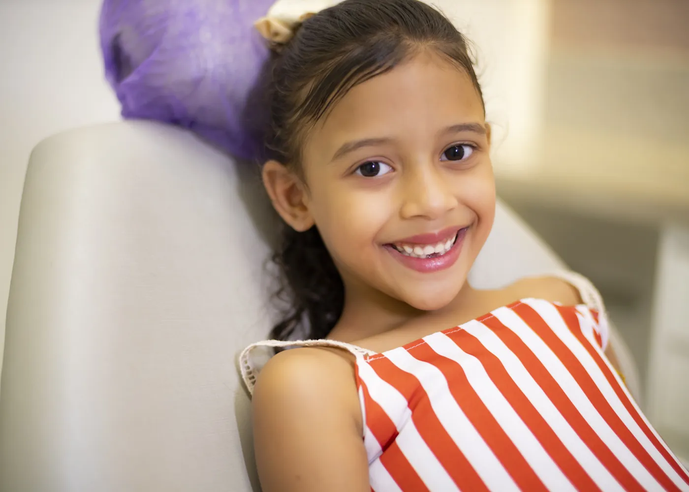 Menina sorrindo na cadeira do dentista