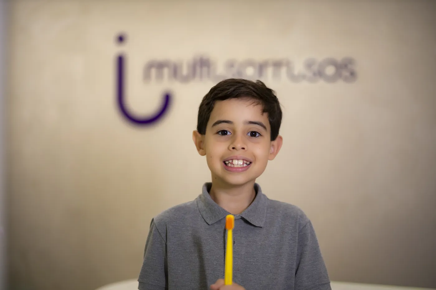 Menino sorrindo com escova de dentes na recepção da MultiSorrisos